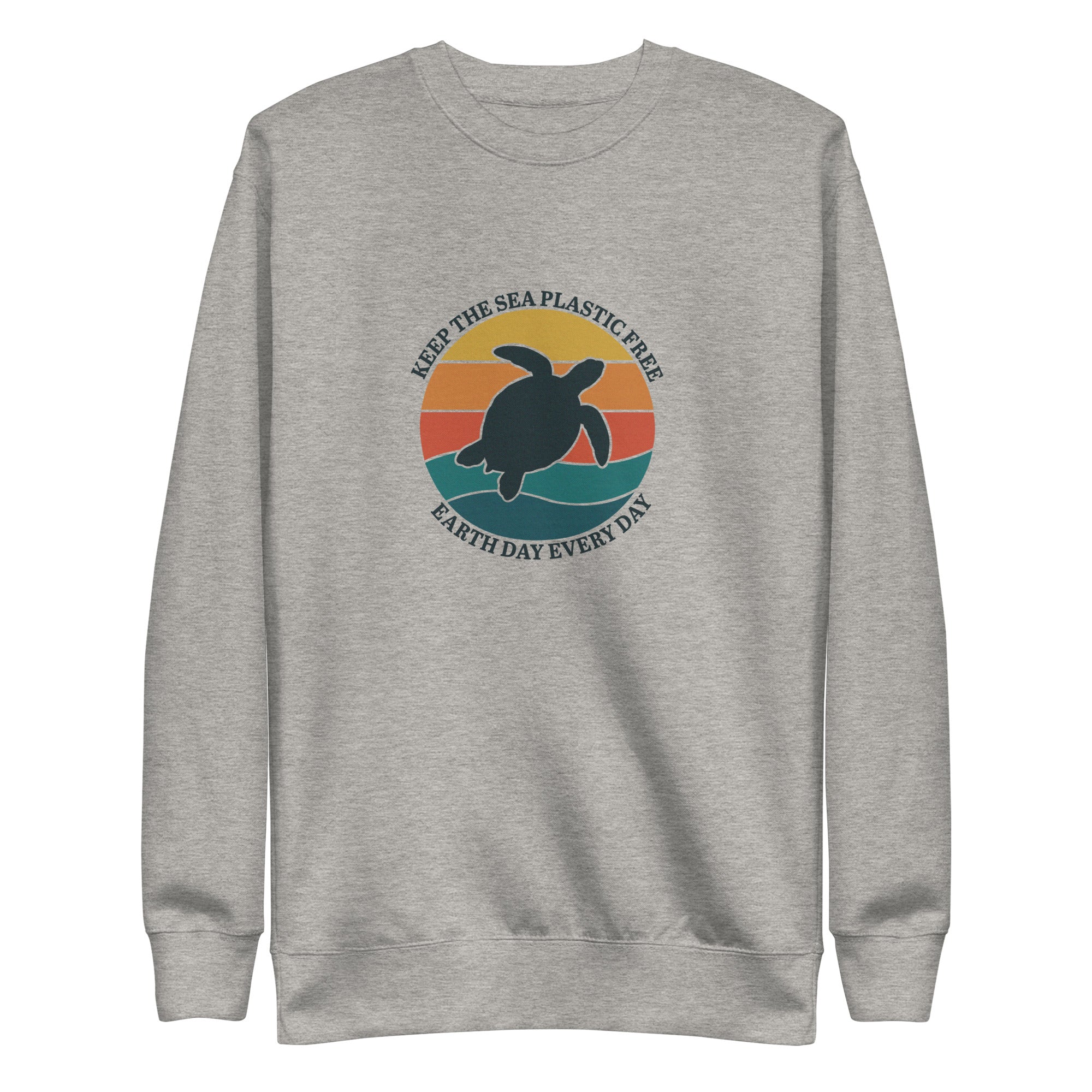 A high-resolution front view of a grey-colored organic crewneck sweatshirt. The central design is a large circular graphic with a retro sunset in shades of orange and teal. A dark silhouette of a sea turtle is centered over waves, surrounded by the text "KEEP THE SEA PLASTIC FREE" and "EARTH DAY EVERY DAY".