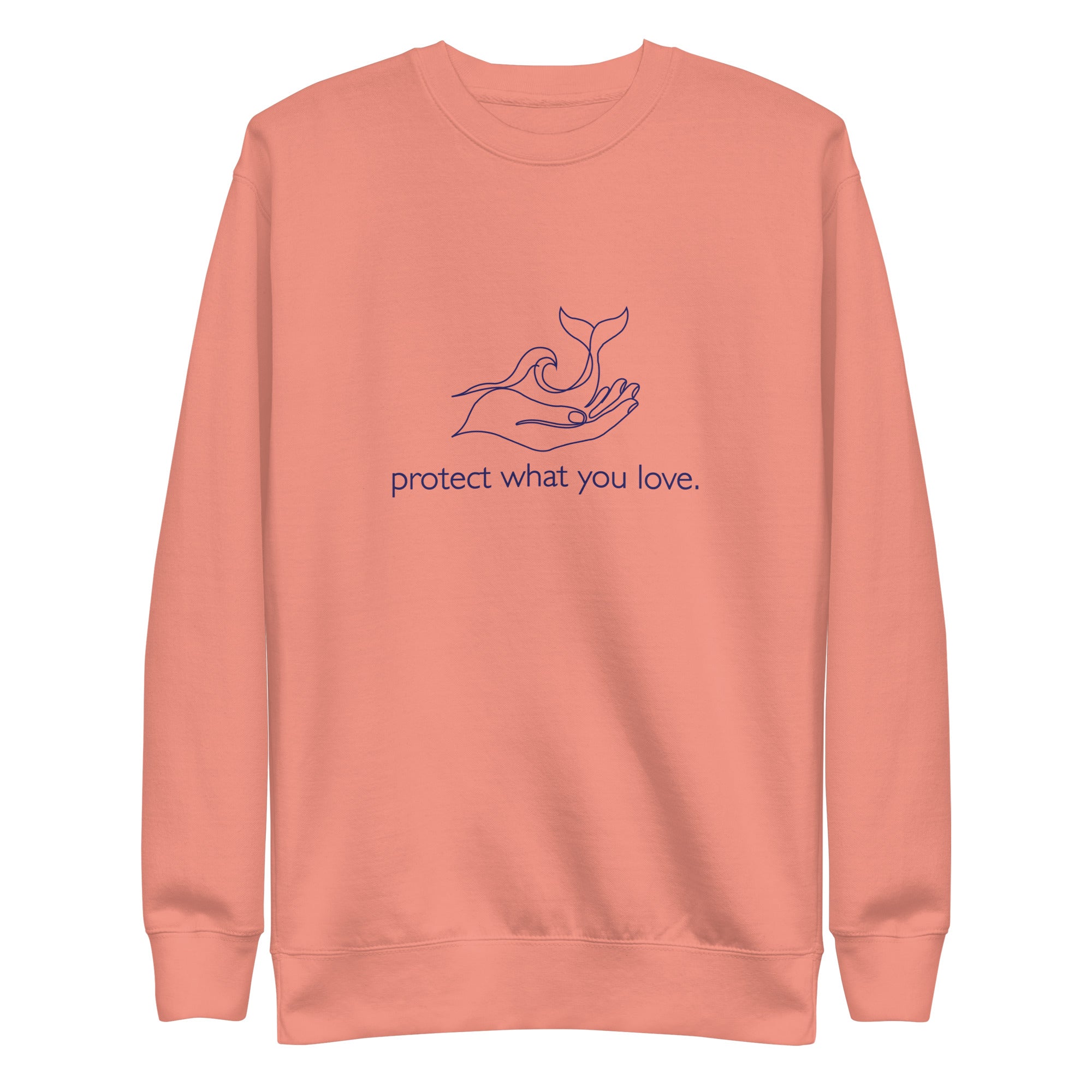 A high-resolution front view of a dusty rose premium crewneck sweatshirt. The central design is a minimalist navy blue line art illustration showing a hand gently cradling a whale's tail and an ocean wave, with the phrase "protect what you love." printed in lowercase below the graphic.