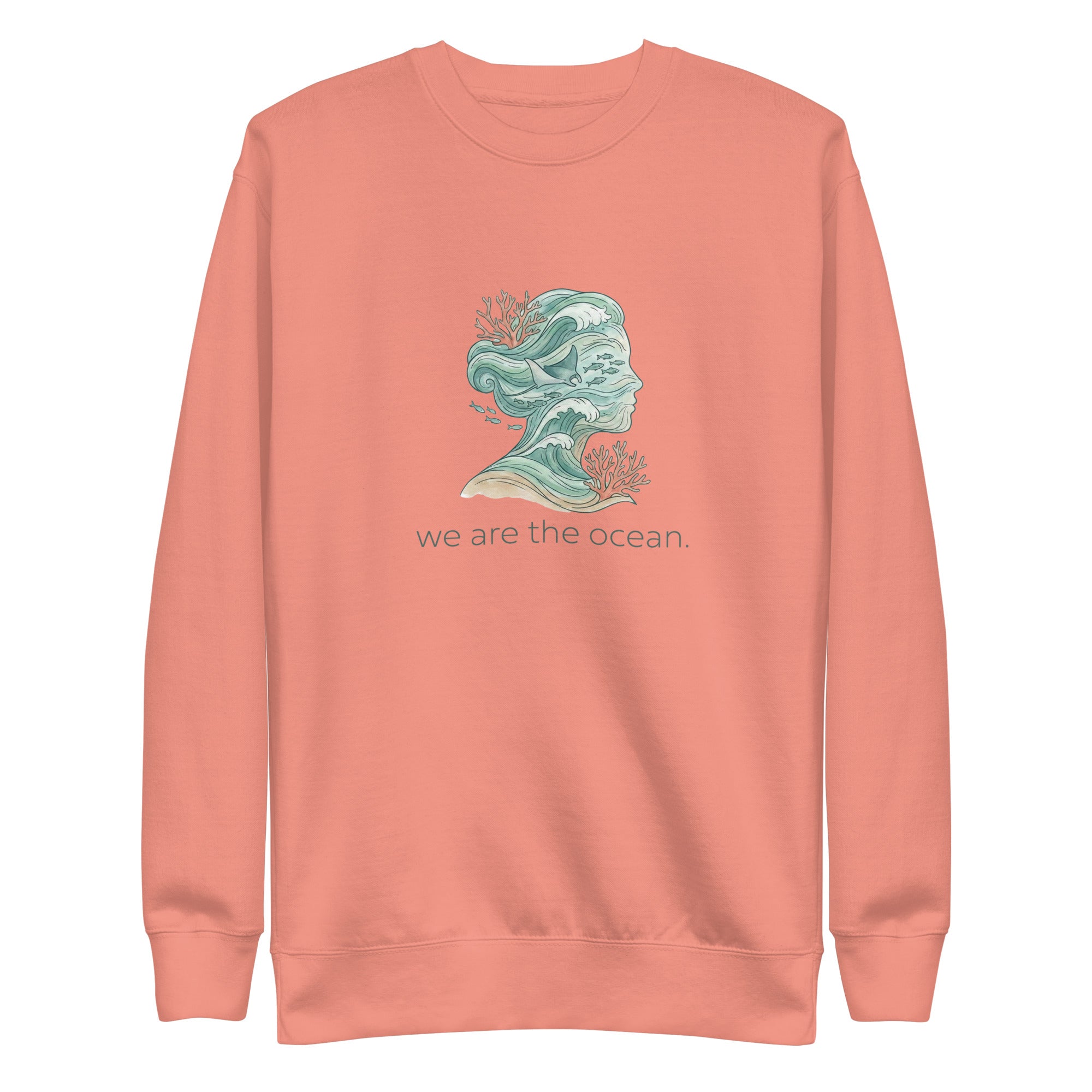 A high-resolution front view of a dusty rose organic hoodie. The central graphic features an artistic silhouette of a human profile filled with teal ocean waves, a stingray, and small fish, accented by orange coral. The text "we are the ocean." is printed in a clean font below the illustration.