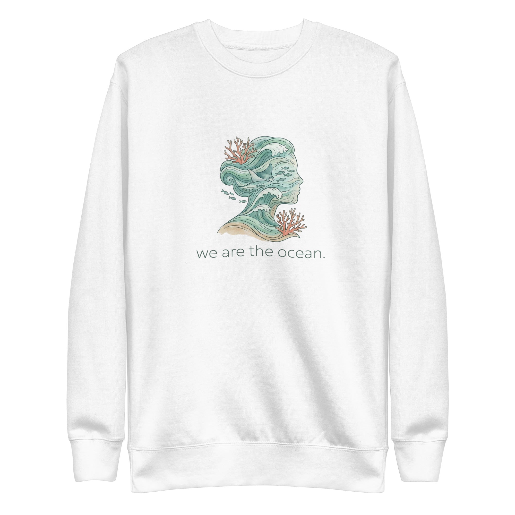 A high-resolution front view of a white organic hoodie. The central graphic features an artistic silhouette of a human profile filled with teal ocean waves, a stingray, and small fish, accented by orange coral. The text "we are the ocean." is printed in a clean font below the illustration.